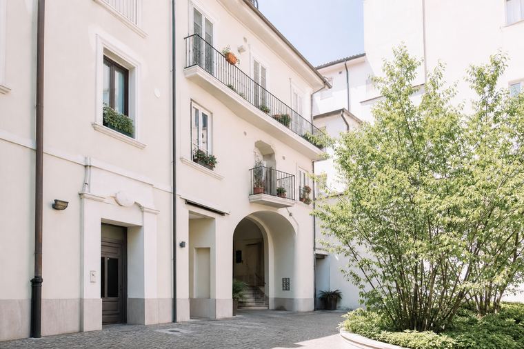 Edifici residenziali grigi e bianchi affiancati, con file regolari di finestre e balconi.